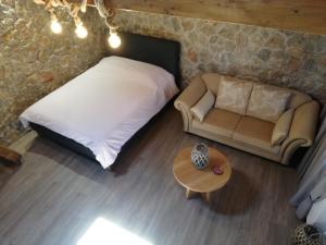1 dormitorio con cama, sofá y mesa en Olympus Country House, en Kariá