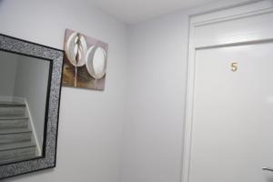 a mirror hanging on a wall next to a door at Budget Ensuite Room Woolwich in London