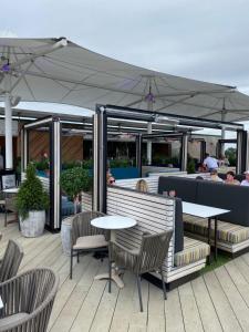 a patio with tables and chairs and an umbrella at Tattershall lakes in Tattershall