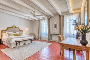 a large bedroom with a bed and a table at Can Alberti 1740 Boutique Hotel in Mahón