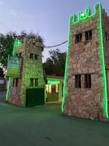 um edifício com luzes verdes ao lado em Sadeem Village & Chalet em Al Shafa