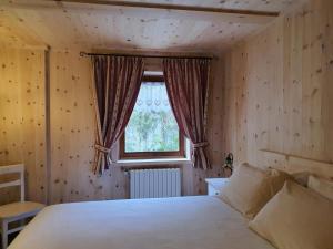 a bedroom with a bed and a window at Casa Sofia in Valdisotto