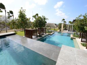 uma imagem de uma piscina numa casa em The Bale Nusa Dua by LifestyleRetreats em Nusa Dua