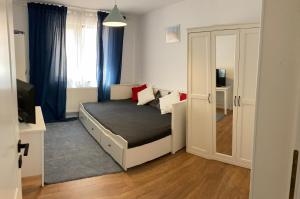 a small bedroom with a bed and a window at Vila Lidia in Eforie Nord