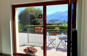 a door leading to a balcony with a table and chairs at B&B I LAKE IT BELLAGIO in Bellagio