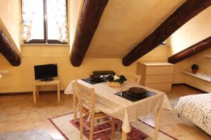 Zimmer mit einem Tisch mit Stühlen und einem TV in der Unterkunft Bellezia in Turin