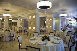 Un salón de banquetes con mesas y sillas con manteles blancos. en Hotel Ristorante Cavaliere, en Scario