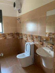La salle de bains est pourvue de toilettes avec un siège et un lavabo. dans l'établissement Sunrise Kadawatha Apartments, à Kadawata