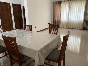 een eettafel met stoelen en een wit tafelkleed bij Sunrise Kadawatha Apartments in Kadawata