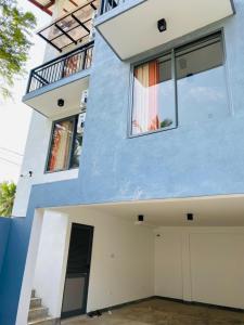 a blue and white house with a garage at Sunrise Kadawatha Apartments in Kadawatha