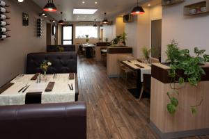 a restaurant with tables and chairs in a room at Logis-Hôtel & Restaurant LE CARNOT in Bolbec