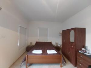 a bedroom with a wooden bed and a dresser at Omodos Maria's Apartments in Omodos