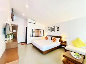 a bedroom with a large white bed and a tv at Family House Zen Boutique Resort in Pai