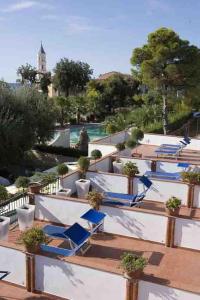 Hotel Ristorante Cavaliere في سكاريو: بلكونه مع كراسي الصاله الزرقاء ومسبح