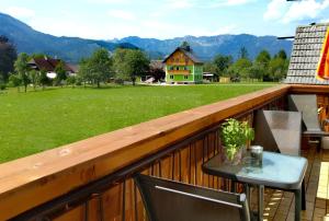 a table on a balcony with a view of a field at Haus Moni in Bad Goisern