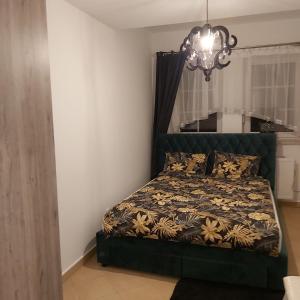 a bedroom with a bed and a chandelier at Nadmorskie Apartamenty in Ustka
