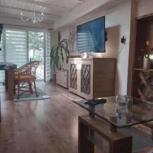 uma sala de estar com uma televisão e uma mesa de vidro em Nadmorskie Apartamenty em Ustka