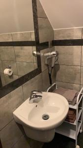 a bathroom with a white sink and a toilet at Dom wczasowy HEEP in Białogóra +55 photos
