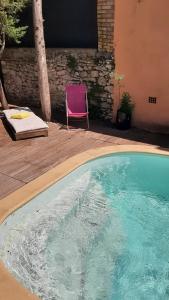 a purple chair sitting next to a swimming pool at Allegria Nimes Chambre Deluxe Spa in Nîmes