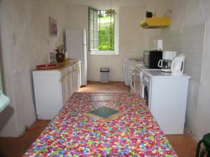 una cocina con una alfombra colorida en el suelo en Gîte de La Ferme de La Cour, en Crasville