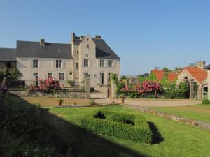 una gran casa blanca con un jardín delante de ella en Gîte de La Ferme de La Cour, en Crasville