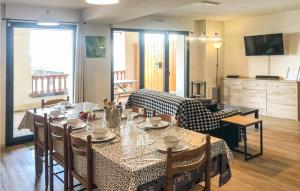 a dining room with a table and chairs and a kitchen at Rsidence Solyneou in La Mongie