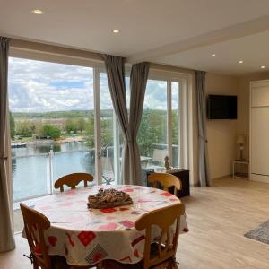 a dining room with a table and a large window at STUDIO VUE SUR MEUSE in Namur