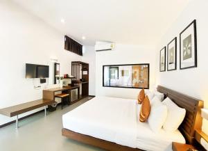 a white bedroom with a bed and a desk at Family House Zen Boutique Resort in Pai
