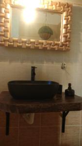 a bathroom with a black sink and a mirror at Chrisambelos Apartments in Istro