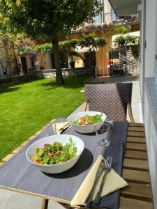 a table with two bowls of salad on a table at Garden Lodge in Stresa