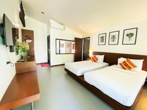 two beds in a hotel room with white sheets at Family House Zen Boutique Resort in Pai