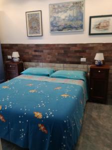Un dormitorio con una cama azul con hojas. en Bilocale alle 5 Terre Monterosso 200m from the beach en Monterosso al Mare