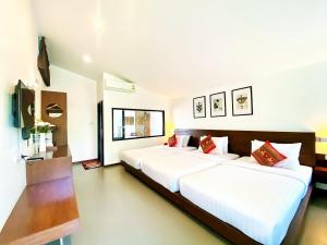a bedroom with two beds with white sheets and red pillows at Family House Zen Boutique Resort in Pai