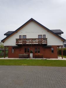 a building with a balcony on top of it at Cztery Pory Roku in Sarbinowo