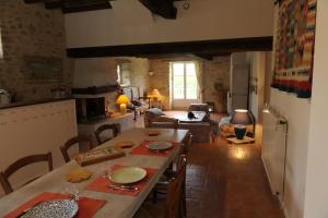 uma cozinha e sala de estar com uma grande mesa de madeira em La Ferme Dagué em Lasseube