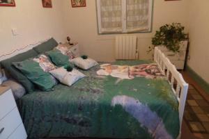 1 dormitorio con 1 cama grande y edredón verde en Aux P'tits loups de cahors, en Cahors
