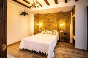 a bedroom with a bed and a stone wall at Maremar Suites in Benidorm