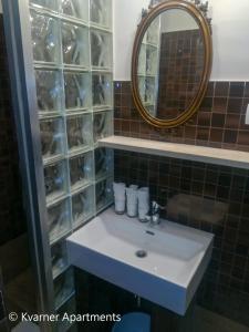 a bathroom with a white sink and a mirror at Kvarner Apartments - Mošćenička Draga in Mošćenička Draga