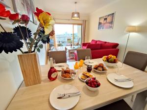a dining room table with plates of food on it at Modern Ocean, Garden & Pool view Condo by BeCherish in Albufeira