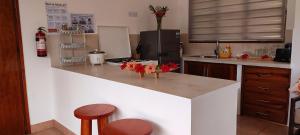 a kitchen with a counter with stools and a refrigerator at Chalets Des Vacances in Takamaka