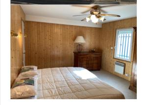 een slaapkamer met een groot bed en een plafondventilator bij Une Vue Exceptionnelle in La Trinité-sur-Mer