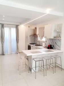 a white kitchen with a table and chairs at "Suite 19" in Tavullia