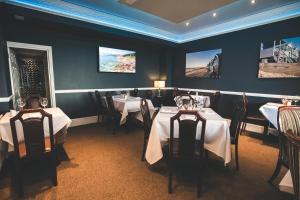 une salle à manger avec deux tables et des nappes blanches dans l'établissement Camelia Hotel, à Southend-on-Sea