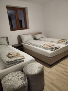 2 Betten in einem Zimmer mit 2 Hockern in der Unterkunft CASA BIA CRIBO Sannicolau de Munte - bai termale in Săcueni