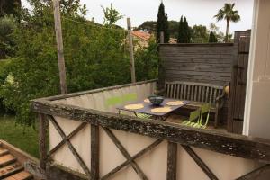 patio ze stołem i krzesłami na balkonie w obiekcie Appartement à 100 m du village de porquerolles w Porquerolles