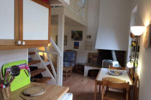 a kitchen and living room with a staircase and a table at Appartement à 100 m du village de porquerolles in Porquerolles