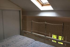 a bedroom with a bed and a skylight at Appartement à 100 m du village de porquerolles in Porquerolles