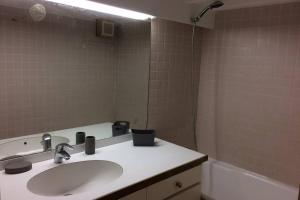 ein Badezimmer mit einem Waschbecken, einem Spiegel und einer Badewanne in der Unterkunft Appartement à 100 m du village de porquerolles in Porquerolles
