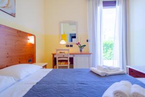 een slaapkamer met een blauw bed en handdoeken bij Delle Rose, Hotel & Restaurant in Torre Vado