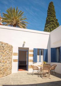 a patio with a table and chairs in front of a white building at Anastasia Traditional House in Lardos